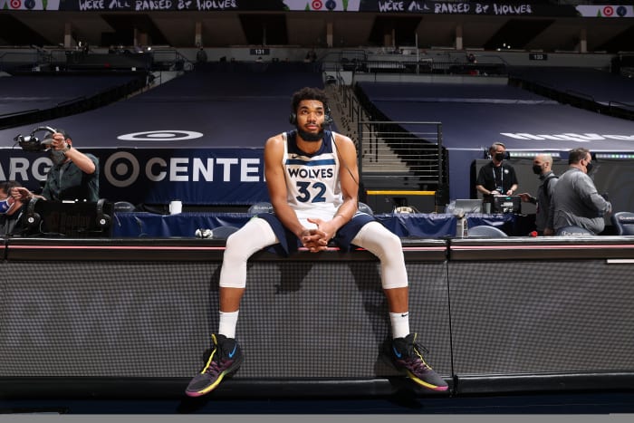 Karl-Anthony Towns sitting on the sideline with a headset on